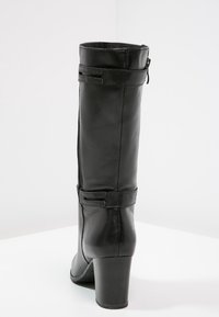 Black leather knee-high boot with a glossy finish, a square heel, and side zipper. Features a textured band at the top and a smooth design.