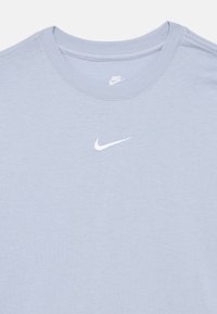 Ανοιχτό γαλάζιο μπλουζάκι Nike με στρογγυλή λαιμόκοψη και μικρό λευκό κεντημένο λογότυπο Nike Swoosh στο κέντρο του στήθους.