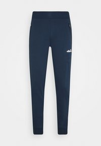 Marinblåa sweatpants i mjukt tyg, med en avsmalnande design, två sidofickor med dragkedja och en vit logotyp på vänster lår.