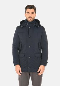 Giacca parka blu navy con cappuccio, caratterizzata da un colletto alto, bottoni frontali e due tasche laterali. Texture liscia e design strutturato.