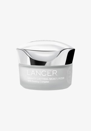 Crème hydratante Lancer Gravity Defying dans un pot gris givré avec un couvercle argenté incurvé. Le texte sur le pot inclut le nom du produit et "avec Complexe Raffermissant".