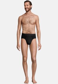 Zwarte slipjes van zacht elastisch materiaal, met een brede tailleband en een afgeronde voorkant. Het ontwerp is simpel en naadloos.