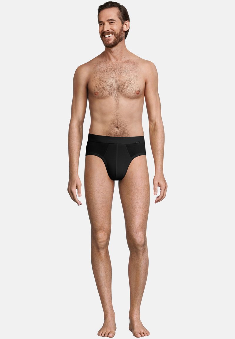 Zwarte slipjes van zacht elastisch materiaal, met een brede tailleband en een afgeronde voorkant. Het ontwerp is simpel en naadloos.