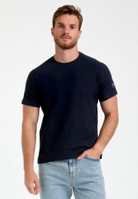 T-shirt blu navy a maniche corte realizzato in cotone testurizzato, con collo a giro e una piccola etichetta con logo sulla manica sinistra.