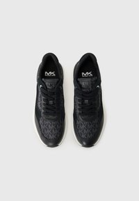Svarte sneakers med en teksturert overdelsstoff og et gjentagende MK-logo mønster, lærdetaljer og en hvit mellomsole.