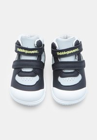 Scarpe per bambini blu e grigie con due cinturini in velcro neri, suola in gomma testurizzata, punta arrotondata e dettagli in rete traspirante.