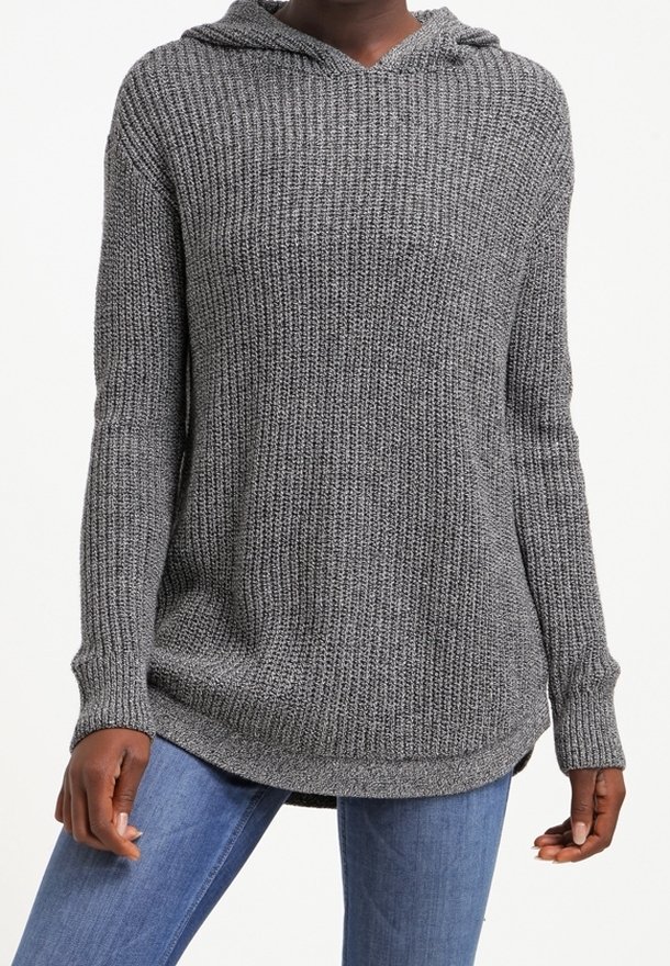 Grijze gebreide hoodie trui met een textuurpatroon, lange mouwen en een gebogen zoom. Heeft een capuchon en een relaxte pasvorm. Gecombineerd met blauwe jeans.