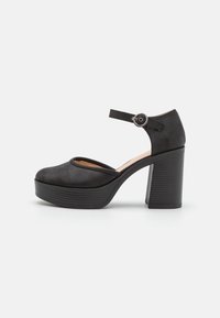 Černá vysoká dámská bota s kulatou špičkou, kotníkovým páskem a kruhovým kovovým doplňkem. Texturovaný svršek a vroubkovaná platforma.