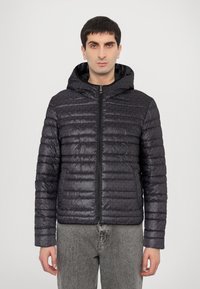 Chaqueta acolchada negra con capucha, que cuenta con un cierre de cremallera en la parte delantera, un patrón sutil y puños elásticos. El material tiene una textura suave y brillante.