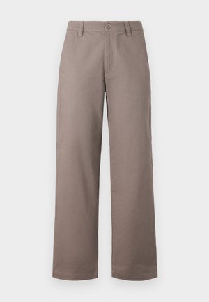 Jasnobrązowe spodnie o szerokich nogawkach z gładkim wykończeniem; posiadają zapięcie na guzik z przodu oraz kieszenie boczne. Wykonane z lekkiego materiału.