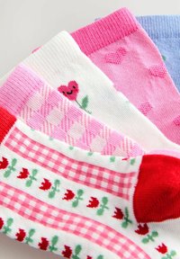 Flerfarvede sokker med mønstre: hjerte-designs, tern og tulipaner. Materialerne er blødt strik i forskellige nuancer af lyserød, hvid og blå.