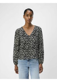 Blouse noire avec motif de feuilles blanches, décollet�é en V, et manches longues avec poignets élastiques ; tissu léger et fluide ; coupe décontractée.