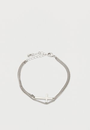 Ezüst lánc karkötő vízszintes kereszt medállal és állítható kapoccsal, fehér háttéren.