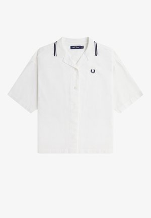 Chemise blanche à manches courtes avec des boutons, un logo de laurier sombre sur la poitrine et des rayures noires sur le col.