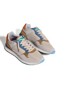 Sneakers con una parte superiore in rete e suede beige chiaro, dettagli in blu e marrone, lacci color crema e suola azzurro chiaro.