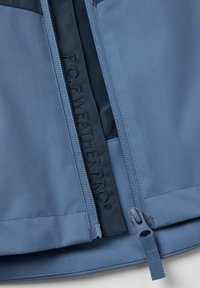 P.O.P. Weather Pro takki, jossa on sininen kangas, sileä pinta, vetoketju ja kohokuvioitu brändäys vetoketjun varrella.