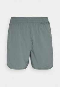 Pantalones cortos deportivos grises con una cintura elástica, textura suave y costuras laterales. Cortados hasta medio muslo con bordes de dobladillo redondeados.