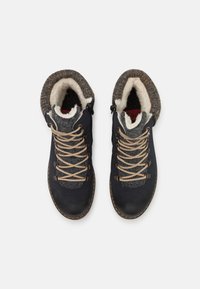 Bottines bleu marine avec un col en tricot gris, doublure en fausse fourrure et lacets beiges. Les semelles sont cousues pour la durabilité.