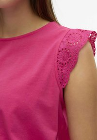Fuchsia T-shirt van katoen met korte mouwen en ingewikkelde kantdetails langs de schouder, wat textuur en ontwerp versterkt.