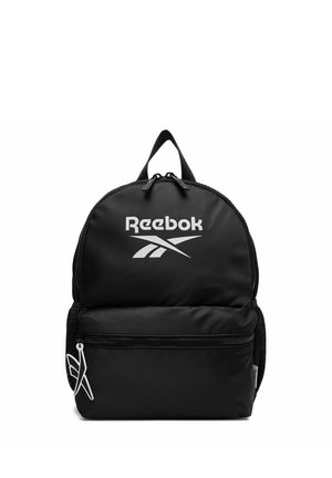 Mochila negra de Reebok con un gran bolsillo frontal con cremallera, asa superior, bolsillos laterales de malla y el logo blanco de Reebok en la parte frontal.