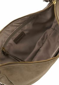 Interno di borsa in suede beige con cerniera bronzo. Presenta una tasca a soffietto e una tasca con cerniera. Fodera in tessuto liscio con etichetta del logo.