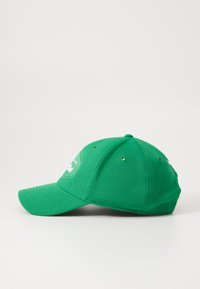 Cappellino da baseball verde con design strutturato, tessuto testurizzato, visiera curva e fori di ventilazione. La parte frontale presenta un dettaglio del logo bianco.