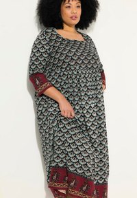 Svart mönstrad maxiklänning med blått blommönster, lös passform, vida ärmar och vinröd kant med detaljerade accenter och kanter.