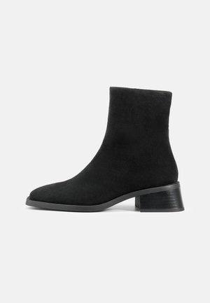 Black suede ankle boot with a rounded toe, short shaft, and a low stacked heel. Smooth texture with no visible patterns or embellishments.