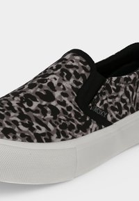 Slip-on αθλητικό παπούτσι με επάνω μέρος από ύφασμα με μαύρο και γκρι λεοπάρ σχέδιο και παχιά λευκή ελαστική σόλα.