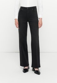 Black denim high-waisted jeans with a straight leg fit, featuring belt loops, front pockets, and a button closure. Smooth texture, minimal detailing.