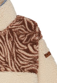 Fleece pullover featuring a cream base with a textured brown patterned overlay and a brown leather tag embossed with "ROXY."