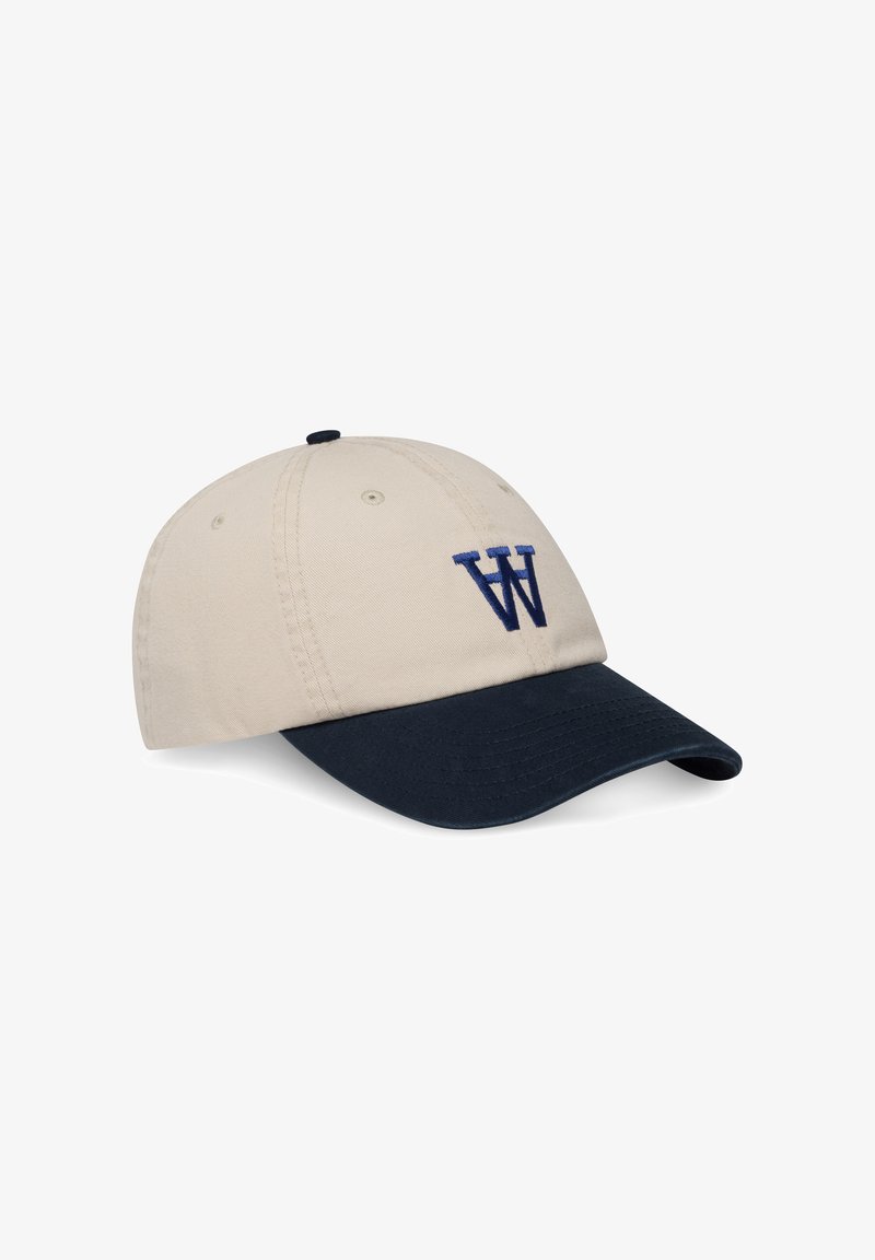 Casquette en coton beige avec une visière marine. Présente un logo "W" brodé en marine à l'avant. Dispose d'œillets de ventilation et d'une sangle ajustable.
