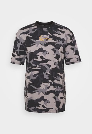 Koszulka w kamuflażu w odcieniach szarości i czerni, z krótkim rękawem, prążkowanym okrągłym dekoltem oraz żółtym akcentem logo na klatce piersiowej.