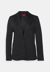 Blazer nero con rever a punta, chiusura a un bottone, due tasche frontali e una texture liscia. Interno con etichetta rossa.