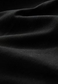 Sort stof med en glat, let tekstureret overflade, der har subtile konturer og folder, hvilket indikerer et tungere materiale.