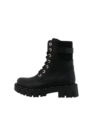 Botte de combat noire en cuir avec semelle épaisse à crampons, lacets à l'avant, bord côte à la cheville et lanière marquée sur le côté.