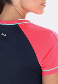 Sportovní tričko FILA s námořnickým tělem, růžovými rukávy a tyrkysovými detaily; vyrobeno z lehkého, prodyšného materiálu.