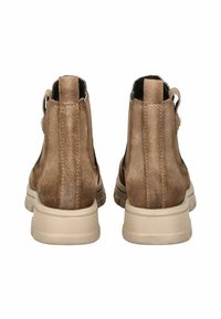 Botas de tobillo de ante marrón con una textura suave, paneles laterales elásticos y una suela de goma de color claro. Diseño sencillo sin patrones.
