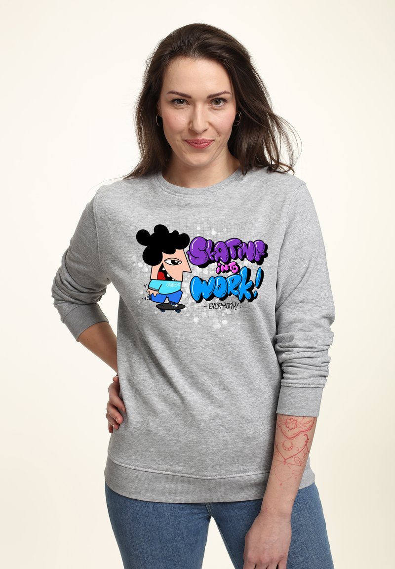 Felpa grigia con un design da cartone animato che raffigura un personaggio su uno skateboard, con il testo "Skatin’ into Work!" in viola e blu.