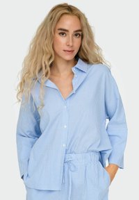 Blauwgestreepte button-up shirt met kraag en lange mouwen; lichtgewicht stof, relaxte pasvorm, met een verstelbare taille in bijpassend materiaal.