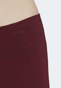 Burgundy sömlösa leggings som har ett mjukt, elastiskt bomullsblandat tyg med en slät midja och en åtsittande passform.