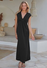 Schwarzes Maxikleid mit V-Ausschnitt und kurzen Ärmeln, mit Raffung an der Brust. Fließender Stoff mit einer glatten Textur.