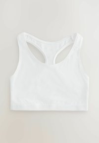 Hvid racerback sports-bh med brede stropper og et sømløst design lagt fladt på en neutral baggrund.