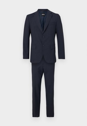 Costume deux pièces marine en tissu texturé, comportant une veste à boutonnage simple avec deux boutons et un pantalon ajusté, soigneusement repassé.