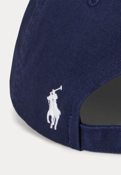 Casquette de base-ball bleue marine en toile de coton, avec un logo brodé blanc représentant un cheval et un cavalier sur le côté. Sangle ajustable à l'arrière.