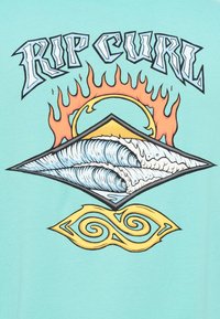 Ανοιχτό μπλε μπλουζάκι με το κείμενο «RIP CURL», ένα γραφικό διαμαντιού με κύματα, φλόγες και στροβιλισμούς σε πορτοκαλί και κίτρινες περιγράμματα.