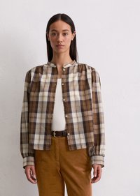 Brown plaid button-up shirt with long sleeves, rounded collar, and elastic cuffs. White undershirt and brown corduroy pants complete the outfit.