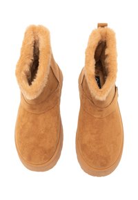 Stivali alla caviglia color cuoio in pelle scamosciata con morbida fodera in pelliccia sintetica, punta arrotondata e suola in gomma texturizzata. Cerniera e passante laterali per una facile calzata.