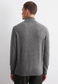 Maglione grigio lavorato a maglia con colletto e polsini a costine, caratterizzato da una finitura texture e un motivo sottile. L'orlo è anch'esso a costine.