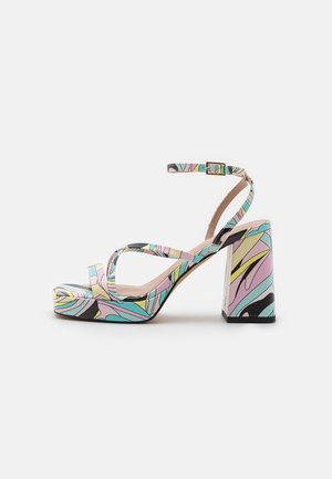 Sandalias de tacón alto coloridas con tacón ancho, patrones florales en rosa, azul y amarillo, con finas tiras en el tobillo y suela plataforma.